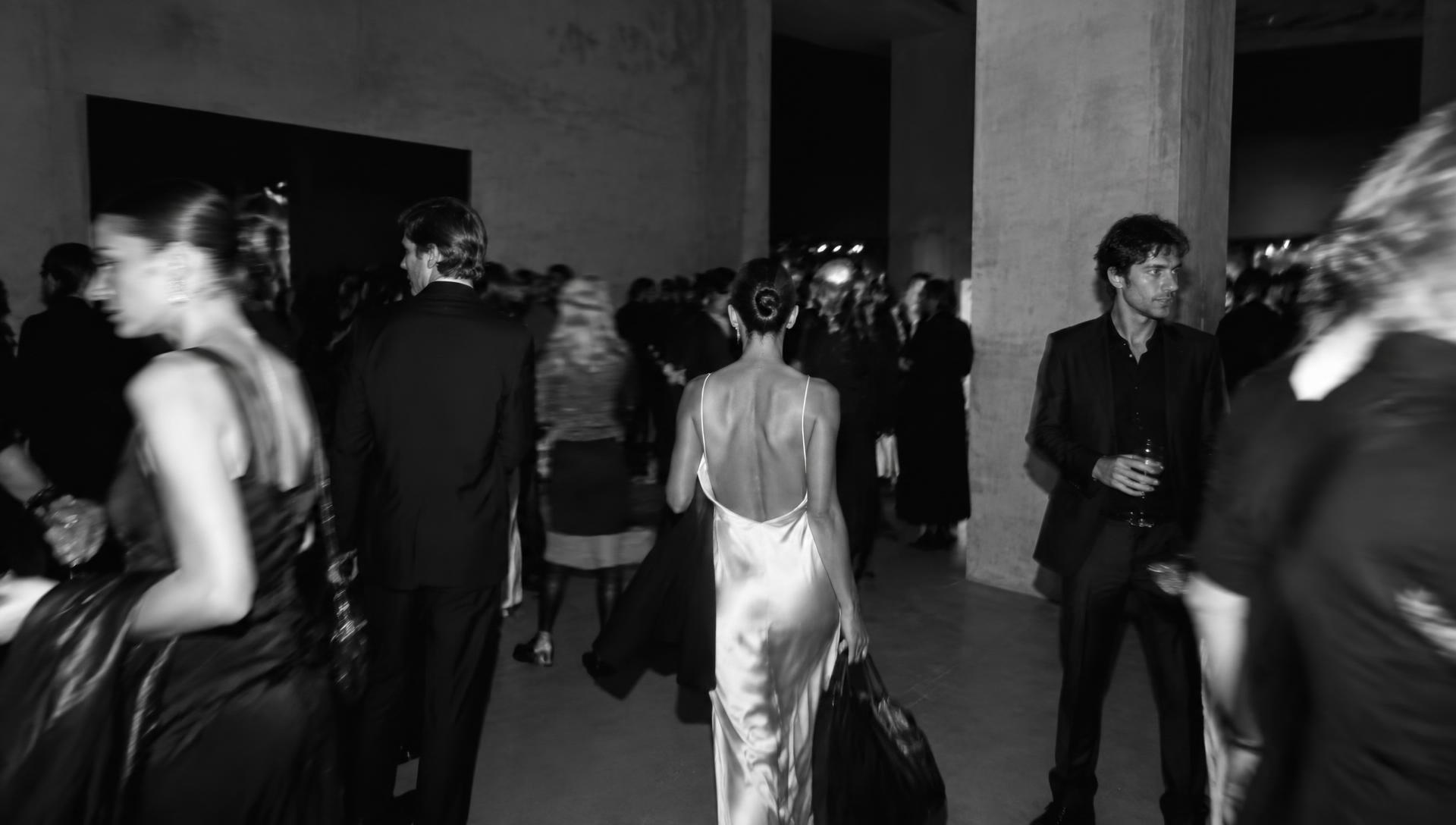 Guests moving through a fashion launch in a concrete gallery