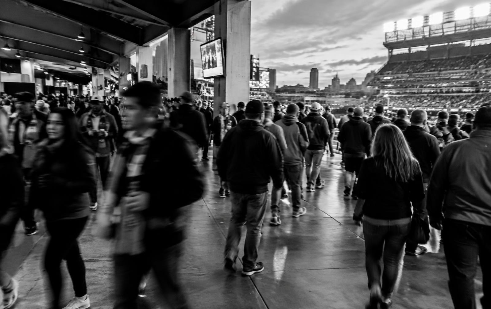 Crowd walking along a stadium concourse at dusk